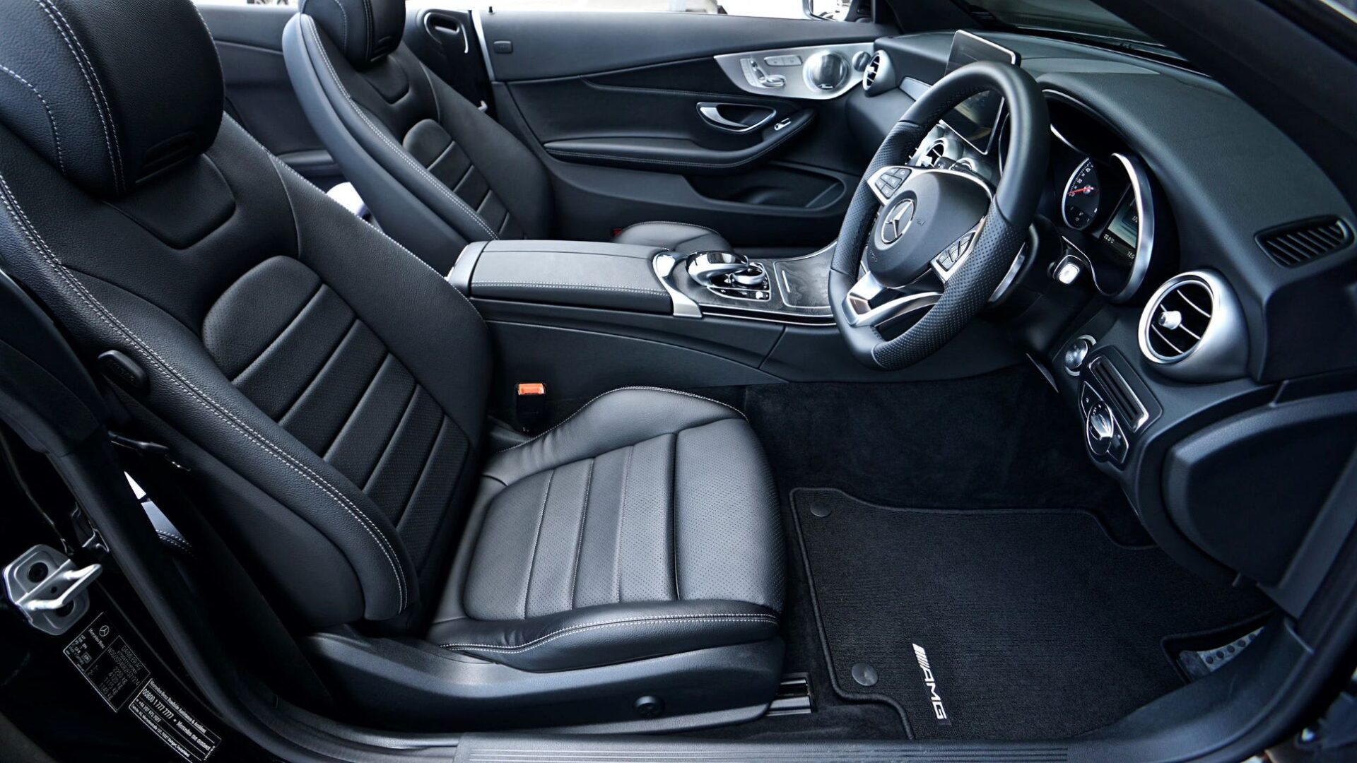 A car with black leather seats and a steering wheel.
